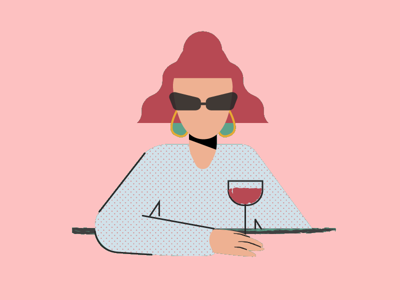 A woman in sunglasses sits at a table with a glass of wine.
